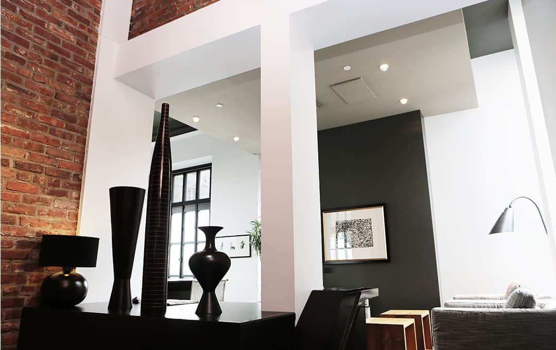 Modern room with columns, black and white paint, and brick wall